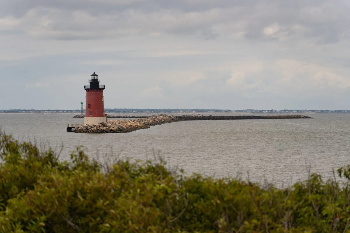 The red Breakwater Lighthouse off Lewes, seen across the dune grass
