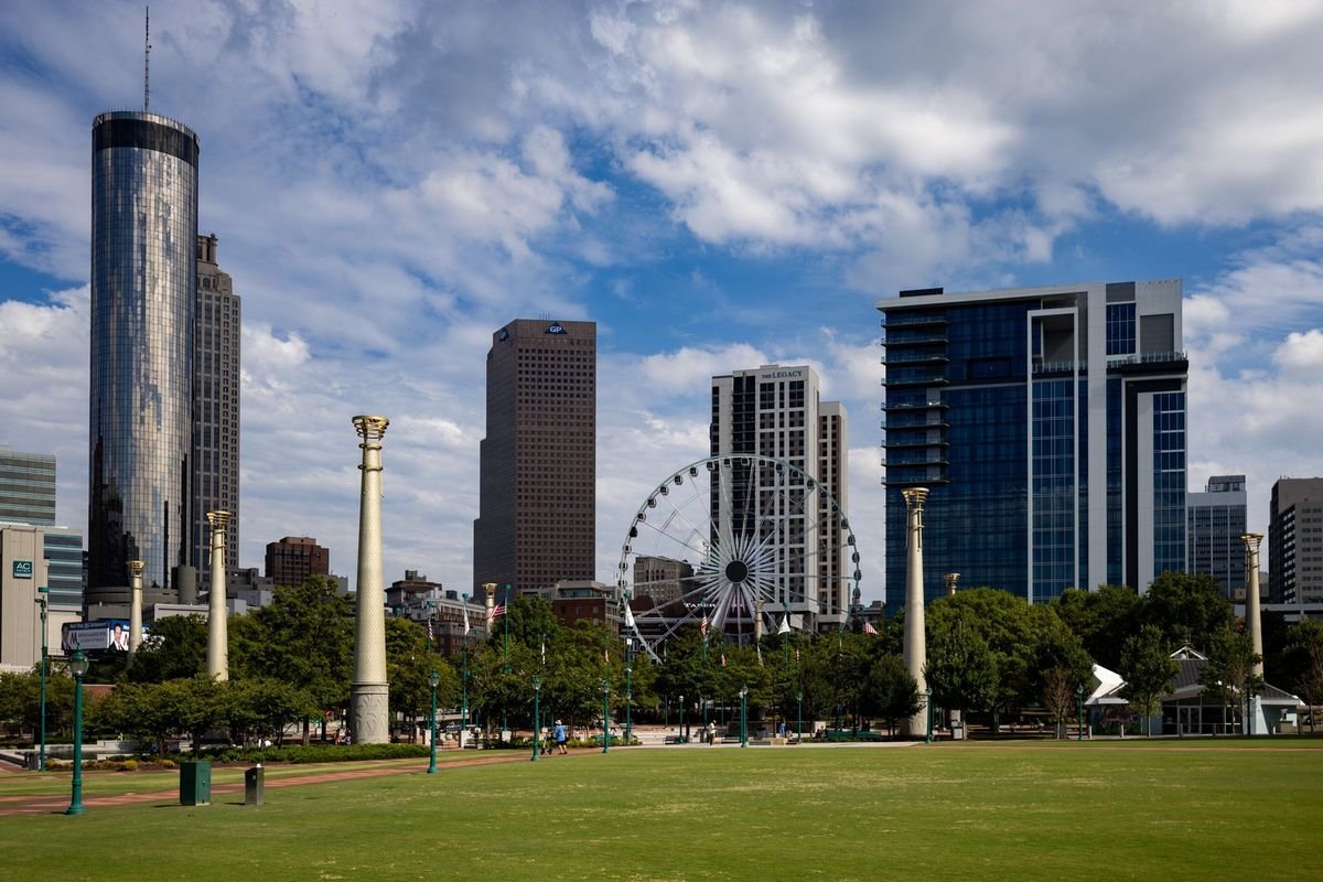 The Atlanta skyline and Ferris wheel seen across the lawn of Centennial Olympic Park