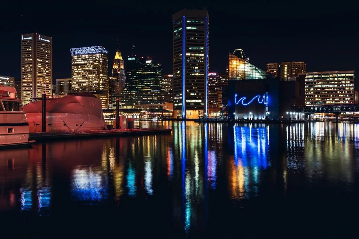 Baltimore's Inner Harbor skyline lit up and reflected in the water at night