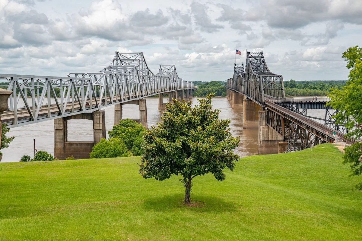 The bridges over the Mississippi River at Vicksburg, seen from a grassy riverside park
