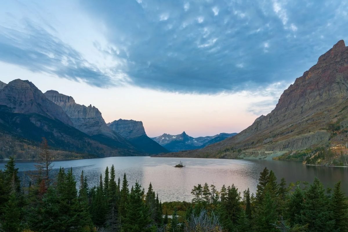 Un lago de montaña rodeado de bosque y picos en el Parque Nacional Glaciar
