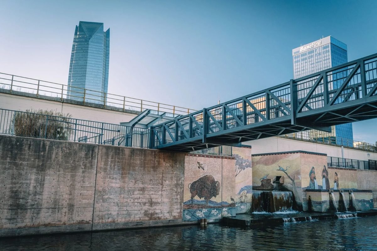 A footbridge over the Bricktown Canal with the Oklahoma City skyline behind