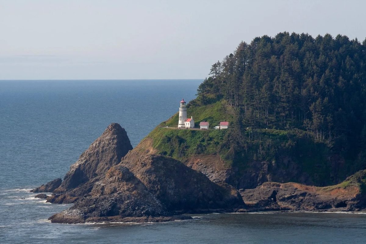 El faro de Heceta Head sobre un cabo con bosque en la costa de Oregón