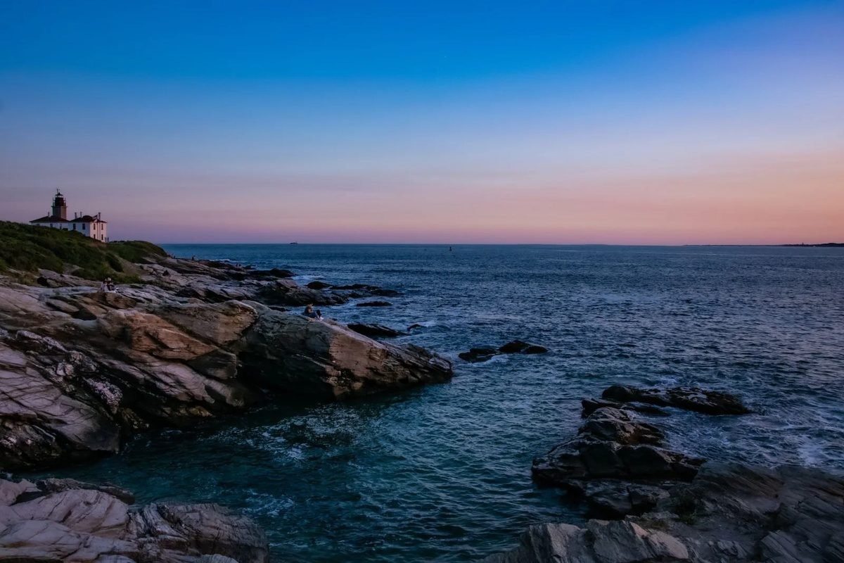 Rocky shoreline at dusk near Beavertail Lighthouse in Jamestown, Rhode Island