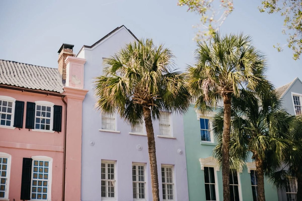 Pastel row houses and palmetto trees on a sunny street in Charleston