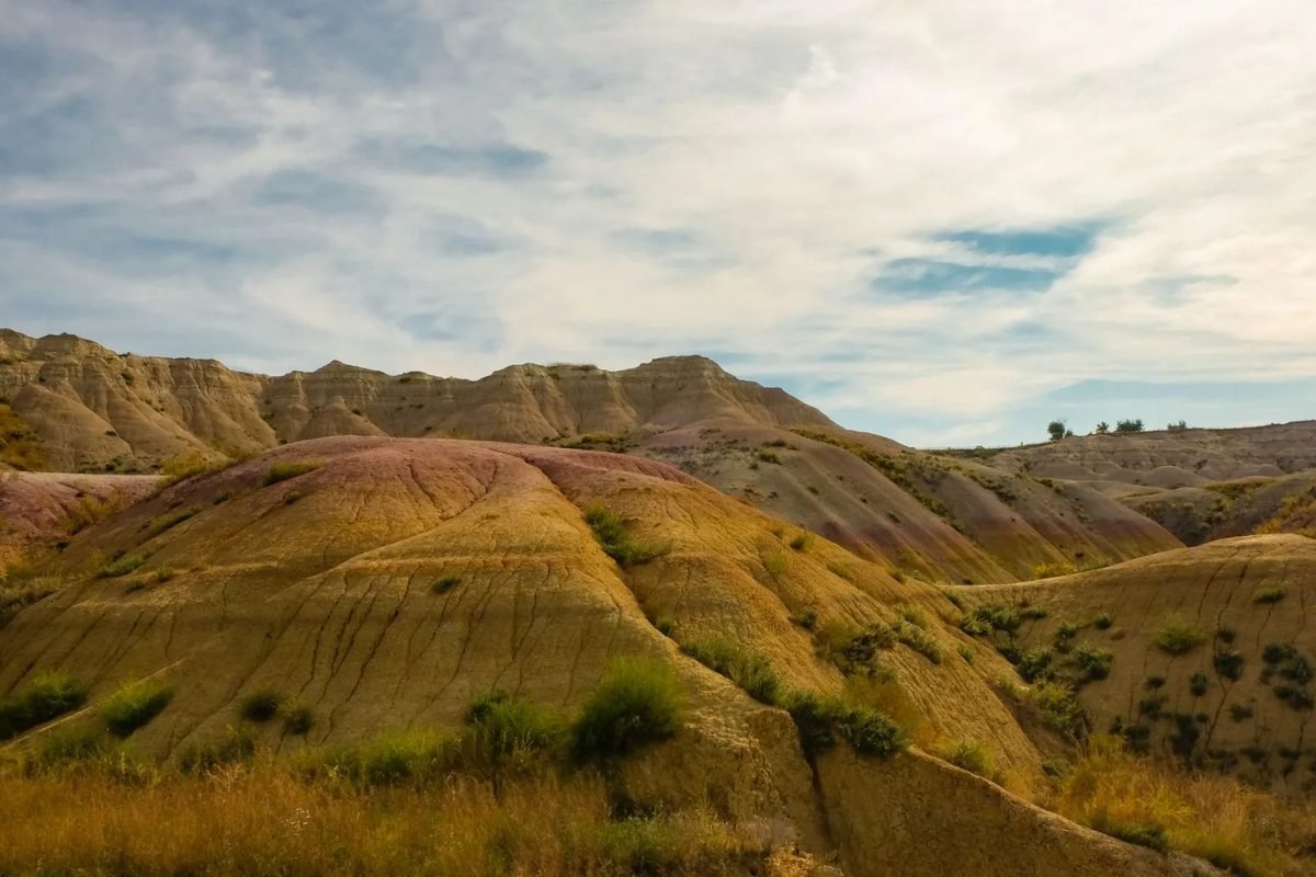 Colinas con franjas de colores cubiertas de hierba en el Parque Nacional Badlands, Dakota del Sur